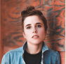 A regular looking person standing near a wall